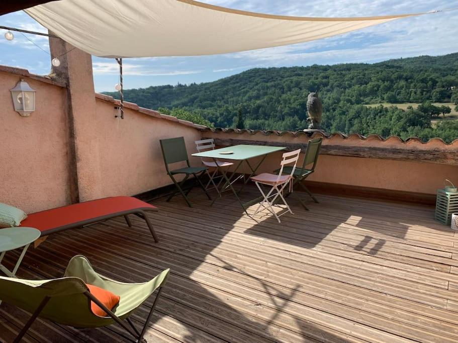 un patio avec une table et des chaises sur une terrasse dans l'établissement Maison des hirondelles petit Luberon, à Niozelles
