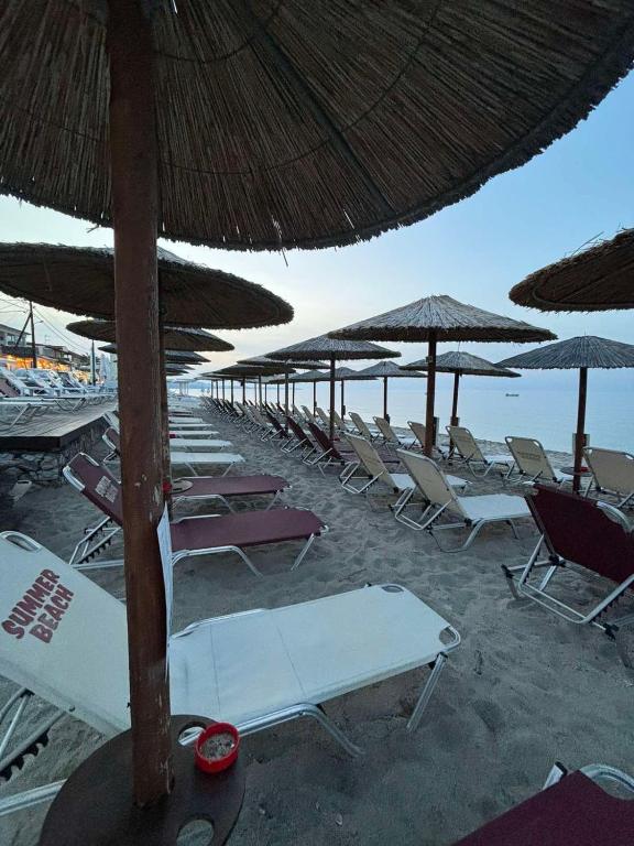 a bunch of chairs and umbrellas on a beach at Summer Beach Hotel in Polychrono