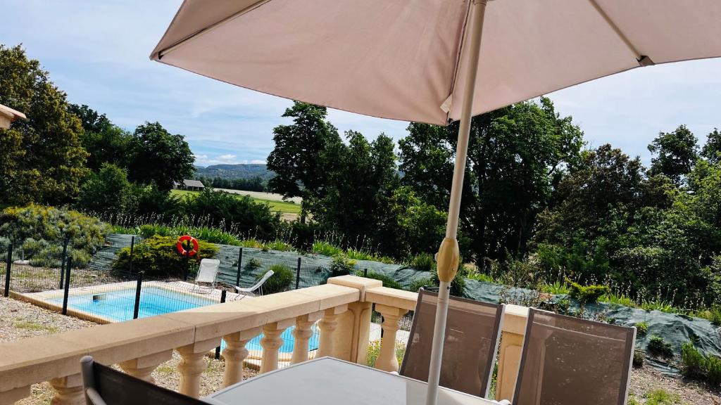 - un balcon avec un parasol et une piscine dans l'établissement Villa avec piscine 3 chambres et 3 salles de bains à Gréoux-les-Bains, à Gréoux-les-Bains