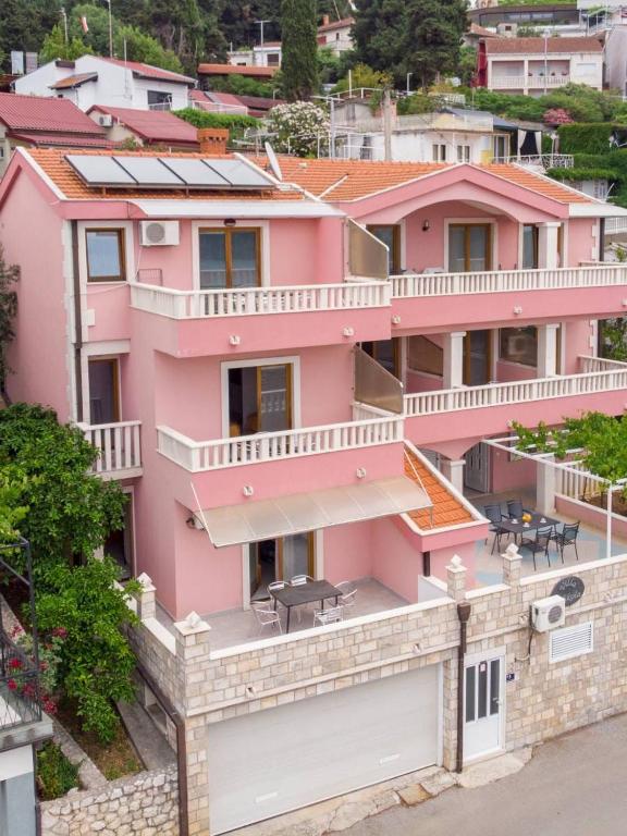 a pink house with solar panels on top of it at Villa Nikola in Neum