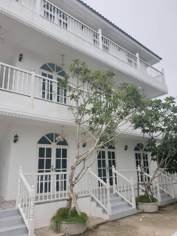a white building with a tree in front of it at Bananaleaf Wedding Cafe & Resort in Ban Bang Kaeo