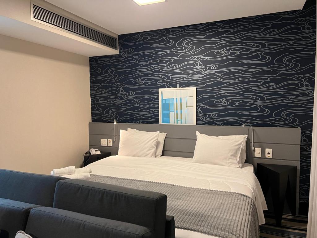 Oscar Freire Hotel RDS Sao Paulo في ساو باولو: غرفة نوم بسرير وجدار ازرق