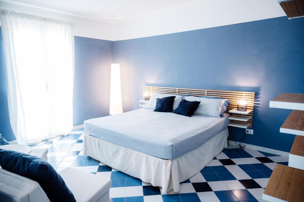 1 dormitorio azul con 1 cama y suelo a cuadros en Villa SognoSalento, en Porto Cesareo