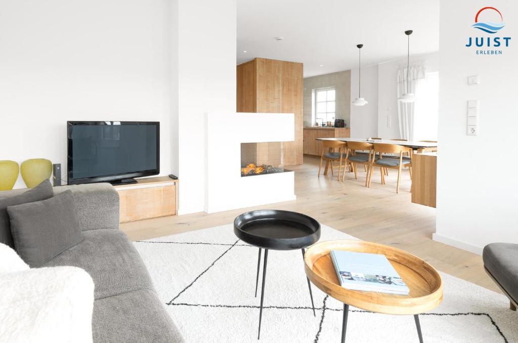 ein Wohnzimmer mit Sofa und Tisch in der Unterkunft Haus Seepferdchen 238 - Ferienhaus Watt in Juist