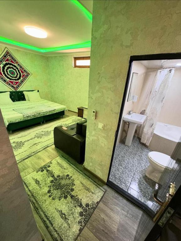 a room with a bed and a bathroom with a mirror at Hotel GOLDEN DEGREZ in Bukhara