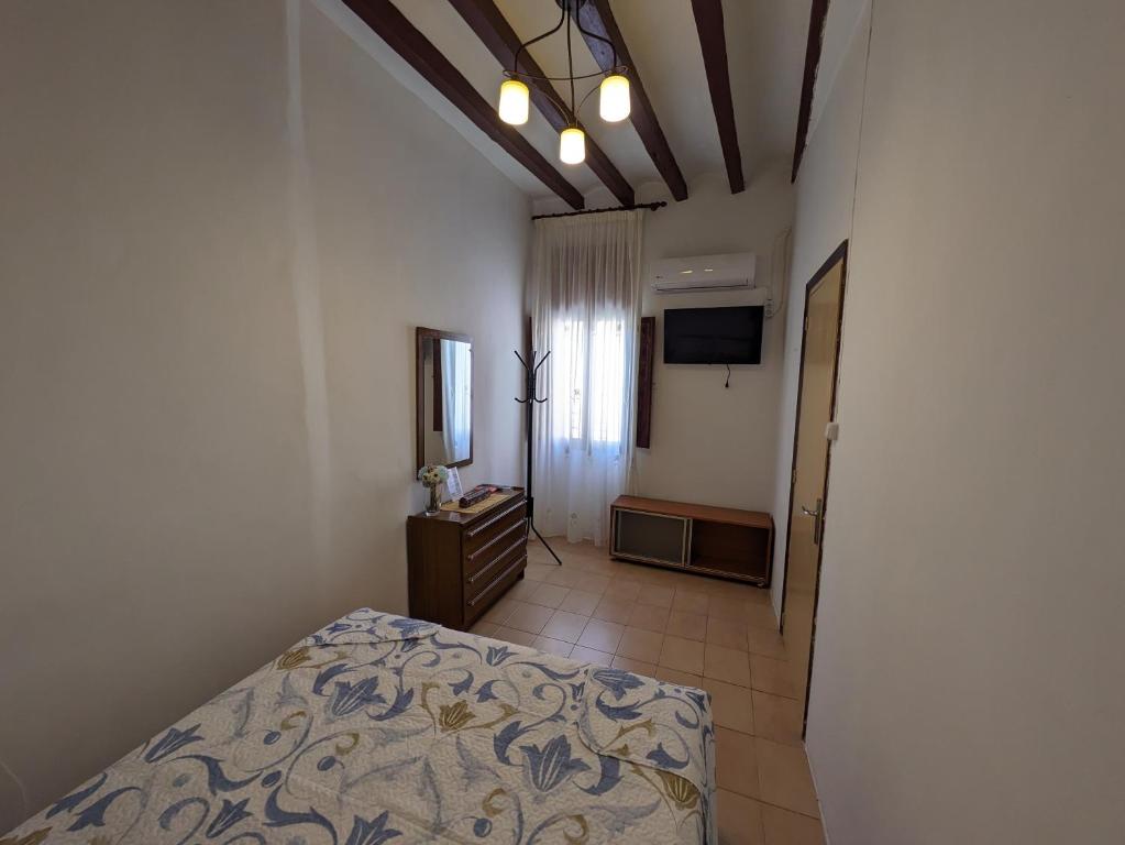 a bedroom with a bed and a television in it at La Muralla in Villajoyosa