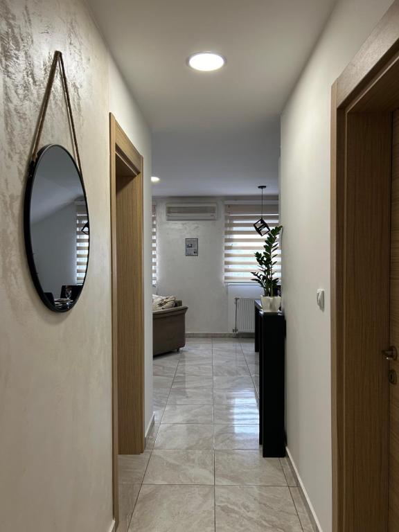 um corredor com um espelho na parede e um corredor sidx sidx sidx em Apartman Gold lux em Surčin