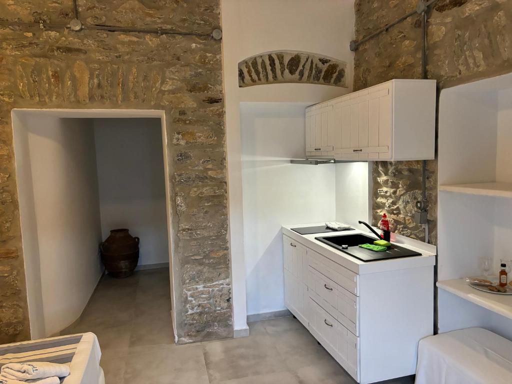 a kitchen with white cabinets and a counter top at Thomas Villas on the beach Katapola in Katapola