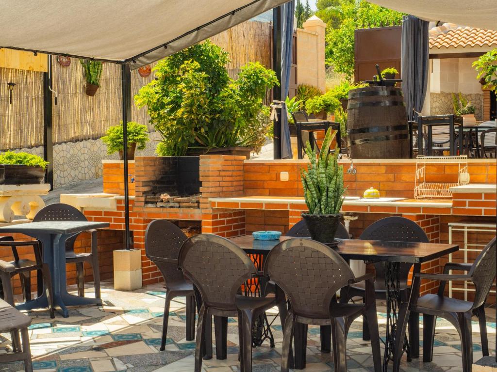 patio ze stołami, krzesłami i sprzętem do grillowania w obiekcie Cubo's Casa El Azahar w mieście Alhaurín el Grande