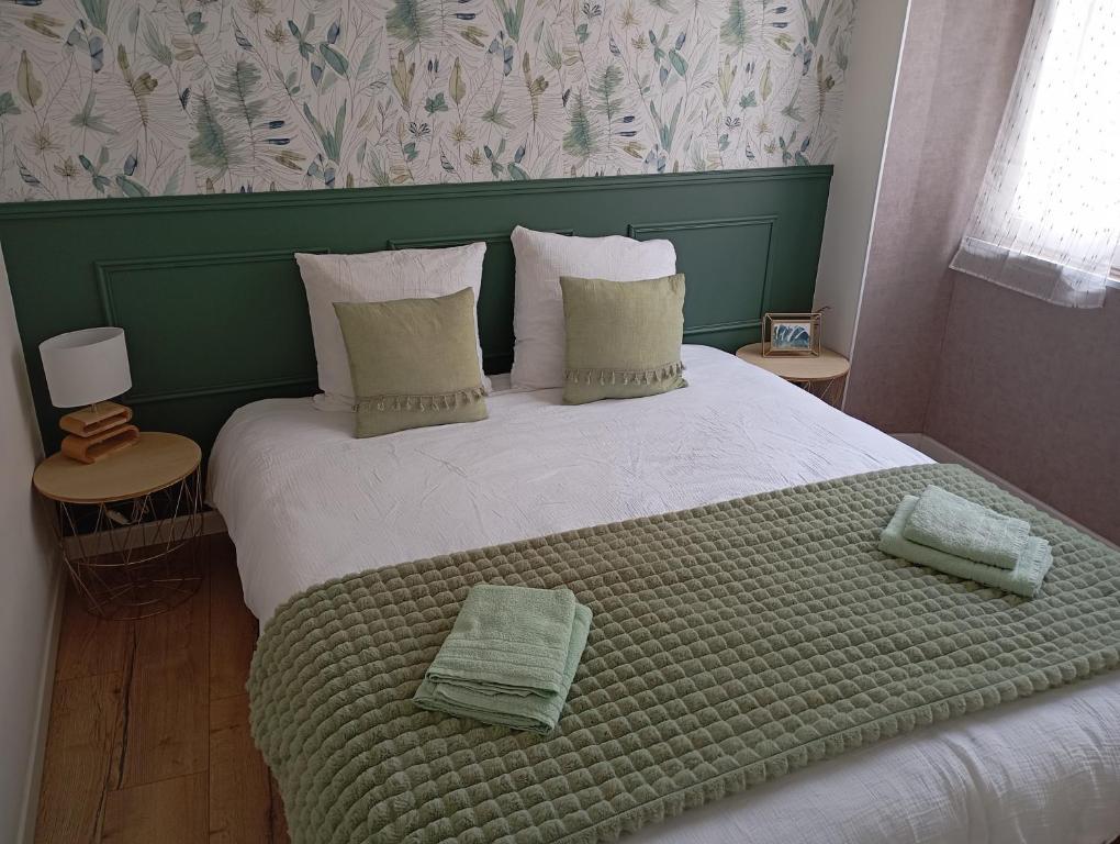 ein Schlafzimmer mit einem großen Bett mit grünem Kopfteil in der Unterkunft Les meublés de Louis-Marie, 2 appartements indépendants pour 4 personnes, 8 personnes au total, proche du Puy du Fou in Saint-Amand-sur-Sèvre