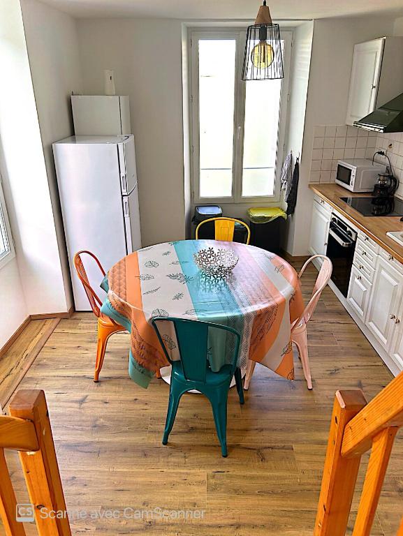 une cuisine avec une table et des chaises dans une cuisine dans l'établissement Superbe duplex cœur de ville 3 étoiles, à Jonzac
