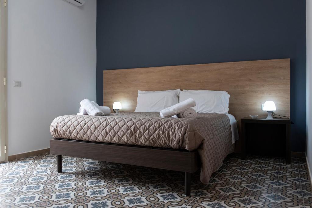 a bedroom with a bed with two lamps on it at B&B Agorà in Naro