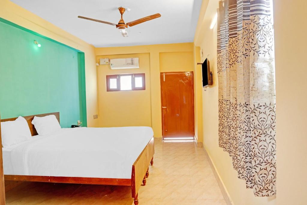 a bedroom with a white bed and a red door at Flagship Veda Residency in Warangal