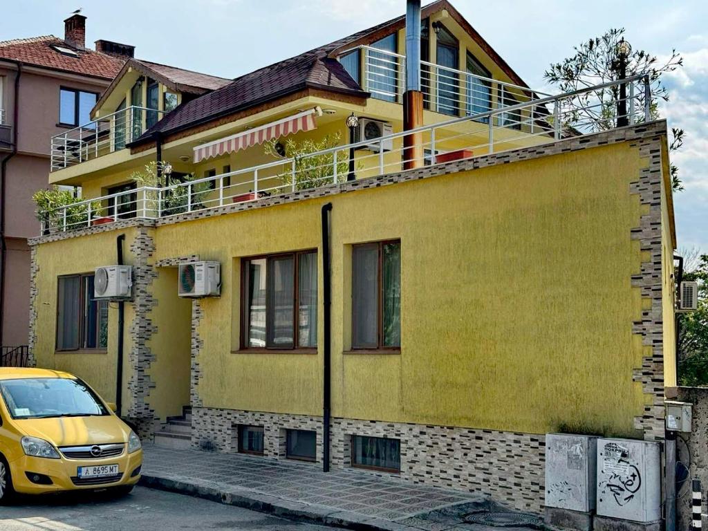 a yellow house with a yellow car parked in front of it at Стаи за гости Гергана град Созопол in Sozopol