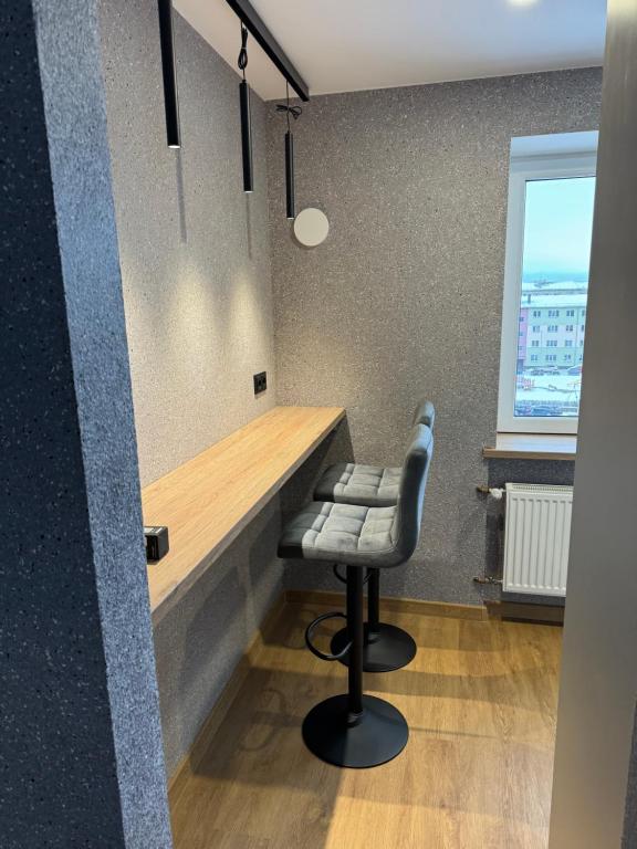 a bar with a bench and a stool in a room at Aleksandra Apartment in Ventspils