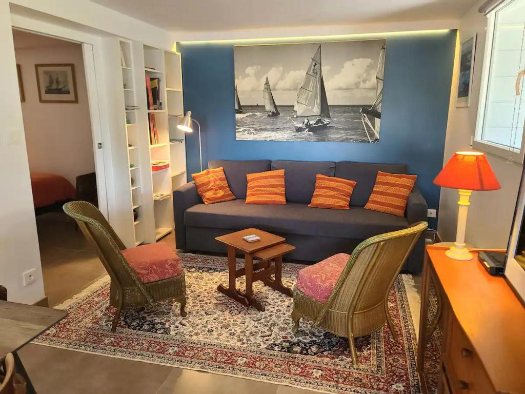 a living room with a blue couch and chairs at Appartement moderne avec terrasse - proche mer in Agon Coutainville