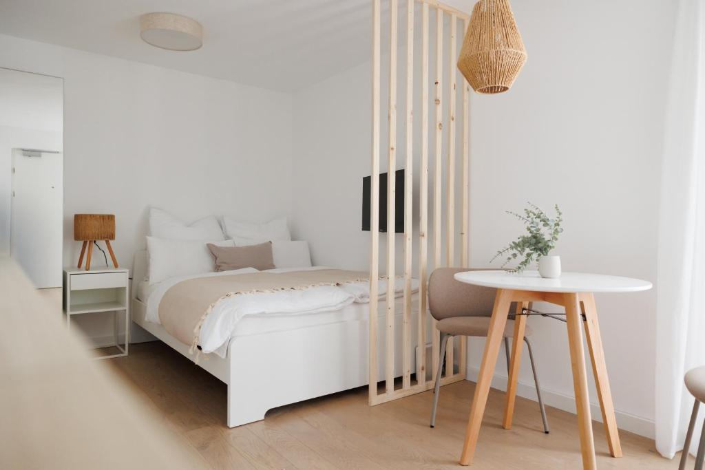 ウィーンにあるBOHO Studio with Terrace - Augarten - 10 min to Centerの白いベッドルーム(ベッド1台、テーブル付)