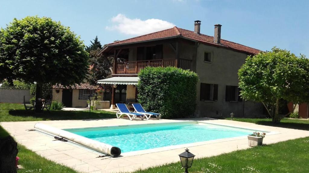 - une piscine avec 2 chaises et une maison dans l'établissement Gîte 4 pers L'Ainstant Présent, à Ambérieux-en-Dombes