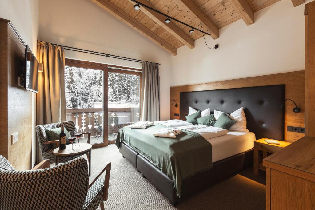 ein Schlafzimmer mit einem großen Bett und einem Balkon in der Unterkunft Mulk Hotel - Joker Card Partner in Saalbach-Hinterglemm