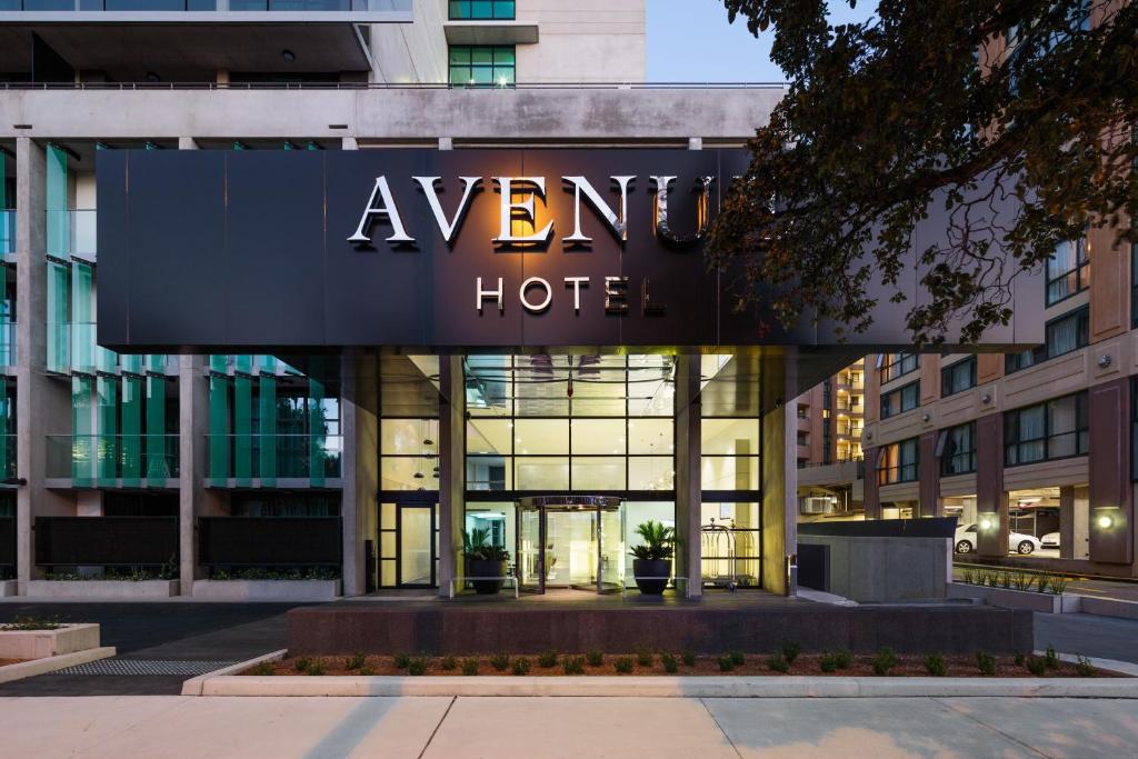 a sign for a hotel in front of a building at Avenue Hotel Canberra in Canberra