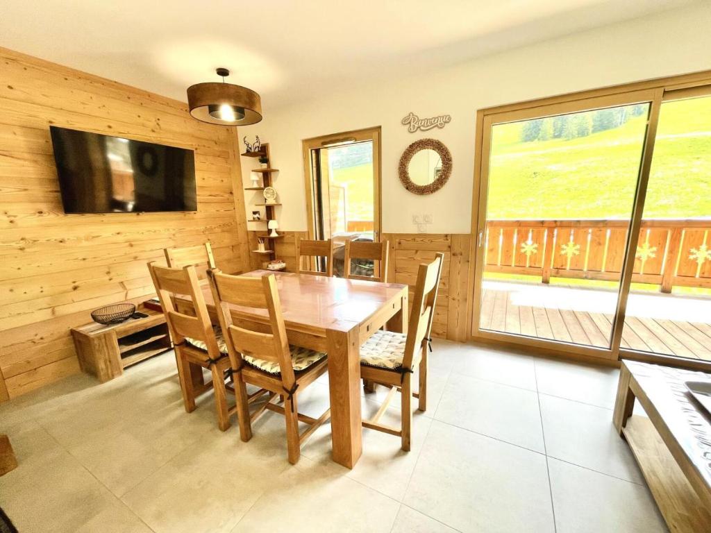 une salle à manger avec une table et des chaises en bois dans l'établissement Résidence Res Cristal - APPARTEMENT NEUF DE CHARME FRONT DE NEIGE MAE-6384, à Notre-Dame-de-Bellecombe