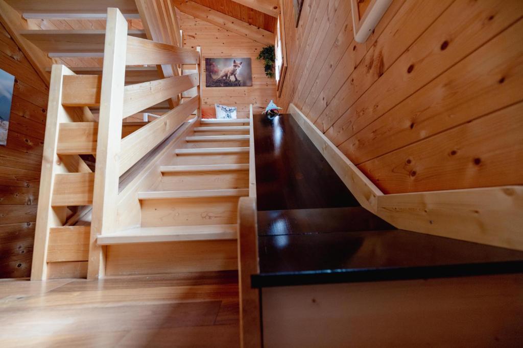 - un escalier dans une cabine dotée de murs en bois et de parquet dans l'établissement Chalet Regenbogen Leukerbad mit Indoorrutschbahn, à Loèche-les-Bains