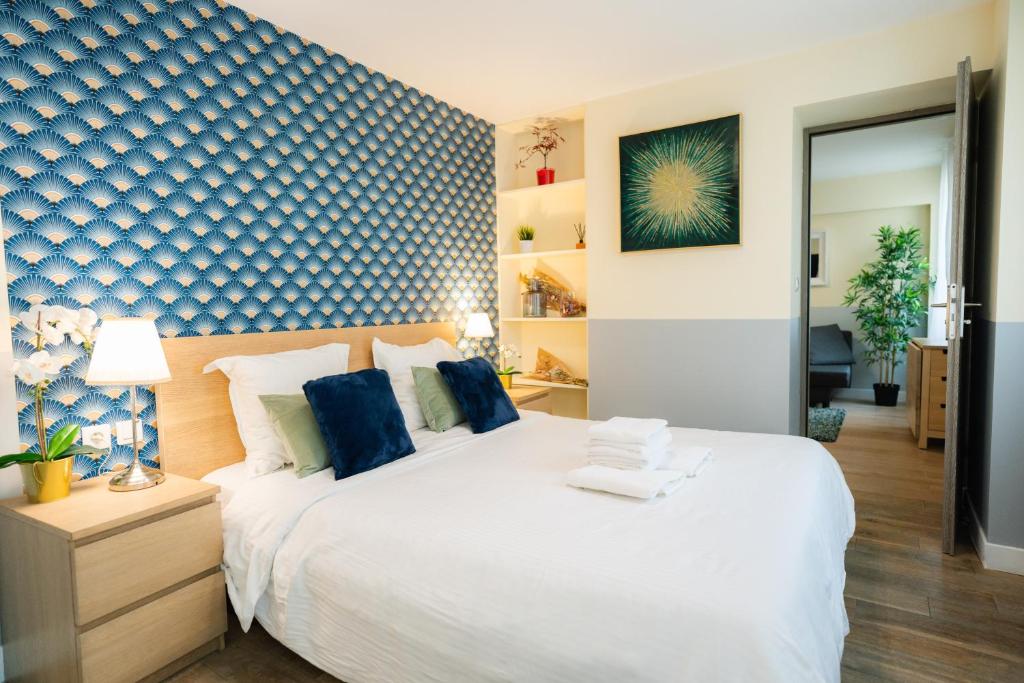 - une chambre avec un lit blanc et un mur bleu dans l'établissement Beautiful yellow apartment near Marais and Bastille, à Paris