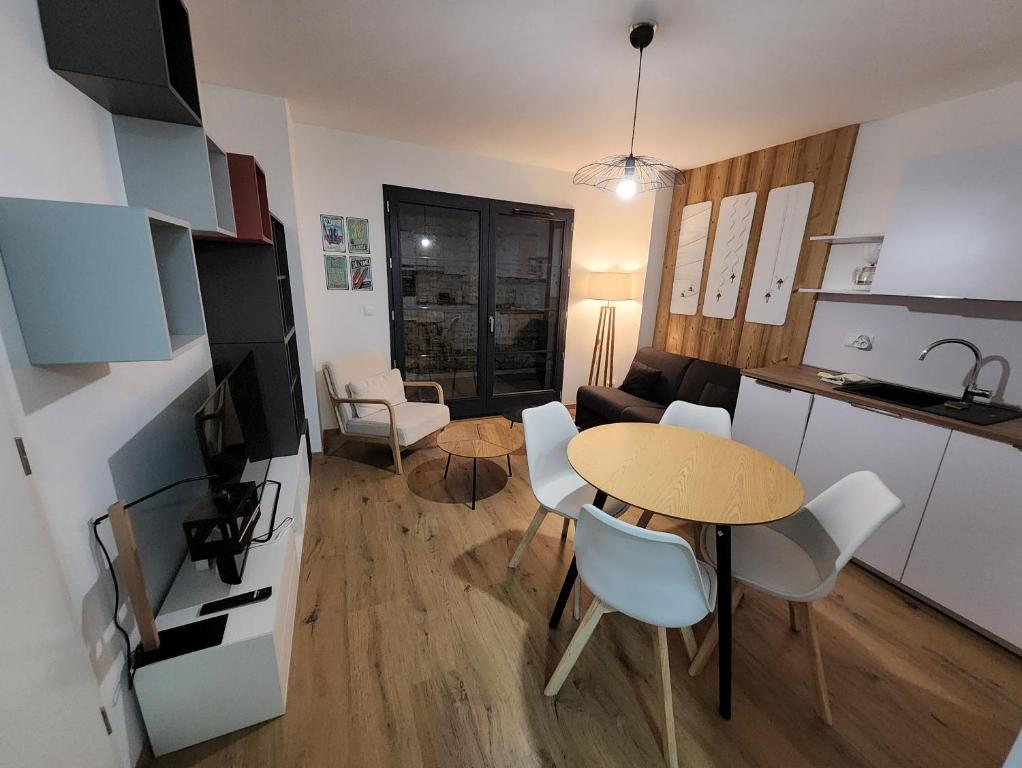 une cuisine et un salon avec une table et des chaises dans l'établissement Appartement proche télécabine, à Saint-Gervais-les-Bains