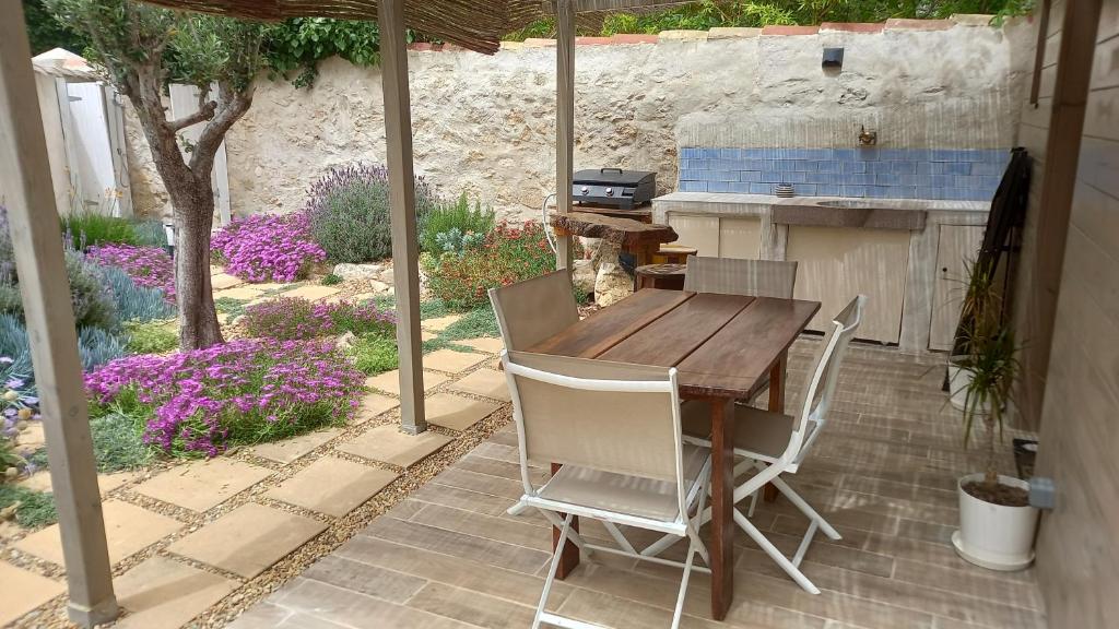 Une table et des chaises en bois sont disponibles sur la terrasse. dans l'établissement Le chalet des lagunes, à Peyriac-de-Mer