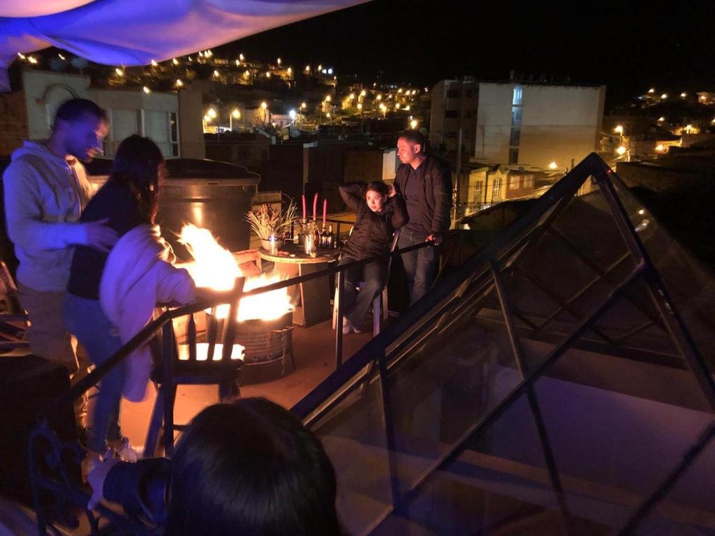 un gruppo di persone che si trovano sul tetto di notte di Amuya Hostel a Chiquinquirá