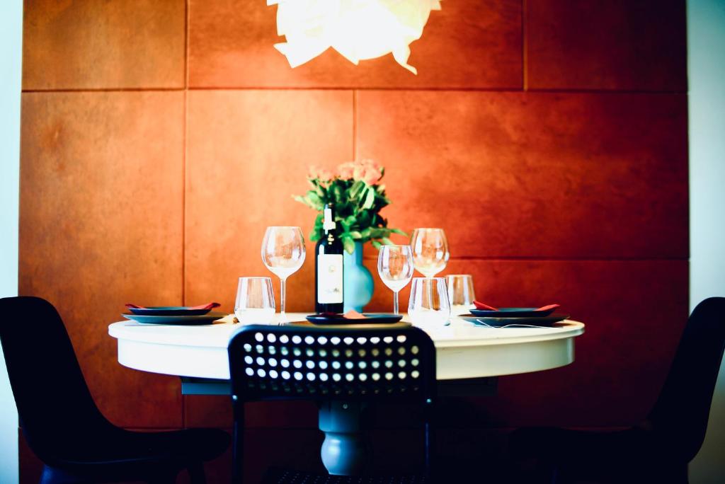 a table with wine glasses and a vase with flowers at Stanislawa Augusta by P&J Apartments in Warsaw