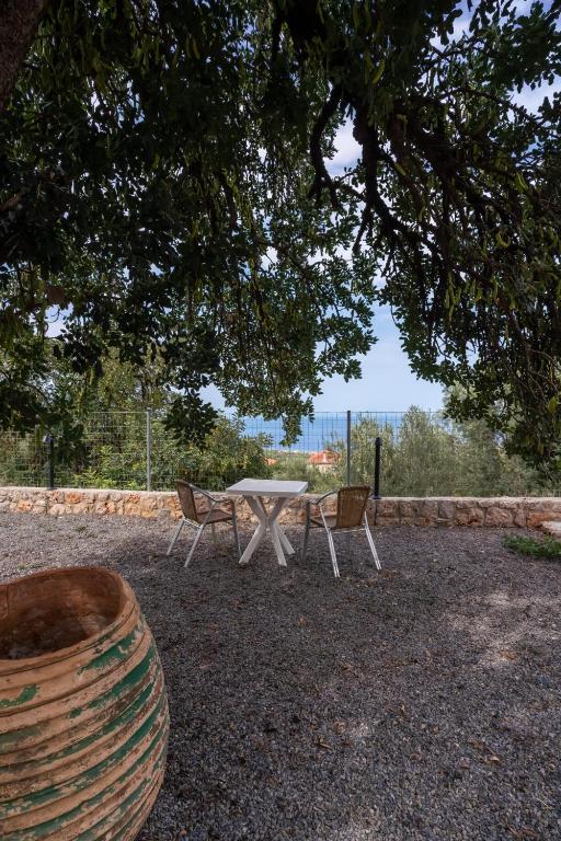 a picnic table and two chairs under a tree at Popi s house in Poulithra