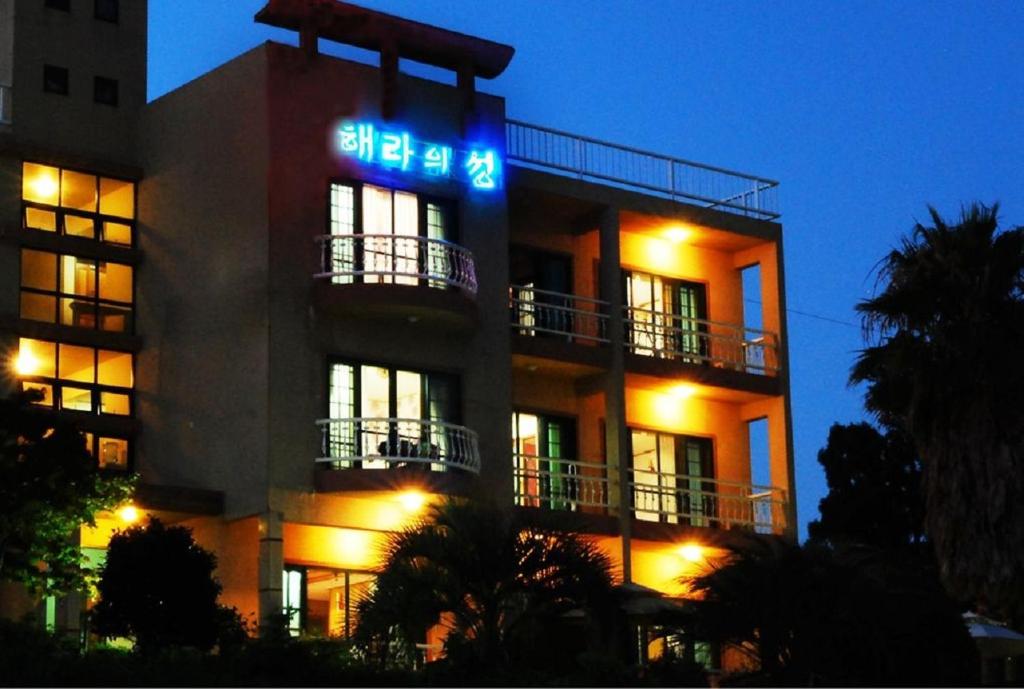 a building with a sign on the side of it at Hera Castle Pension in Seogwipo