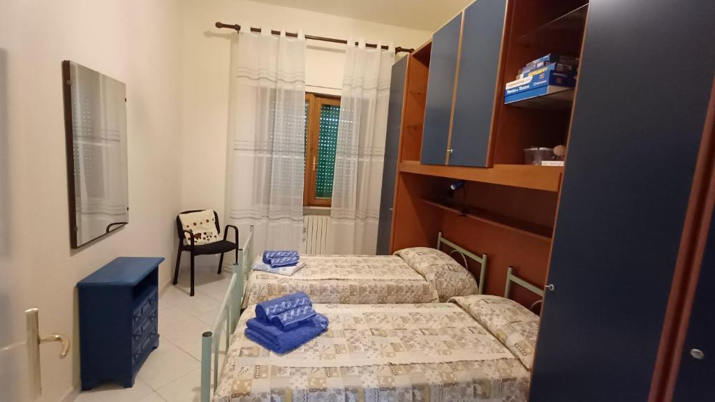 a small room with two beds and a chair at casa vacanze Luisa in Lazzeretto