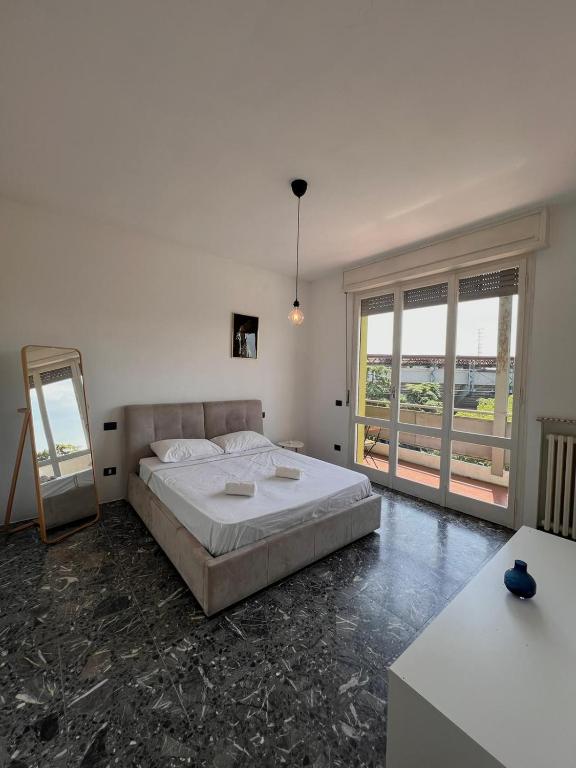a bedroom with a large bed and a large window at mirabello in Reggio Emilia