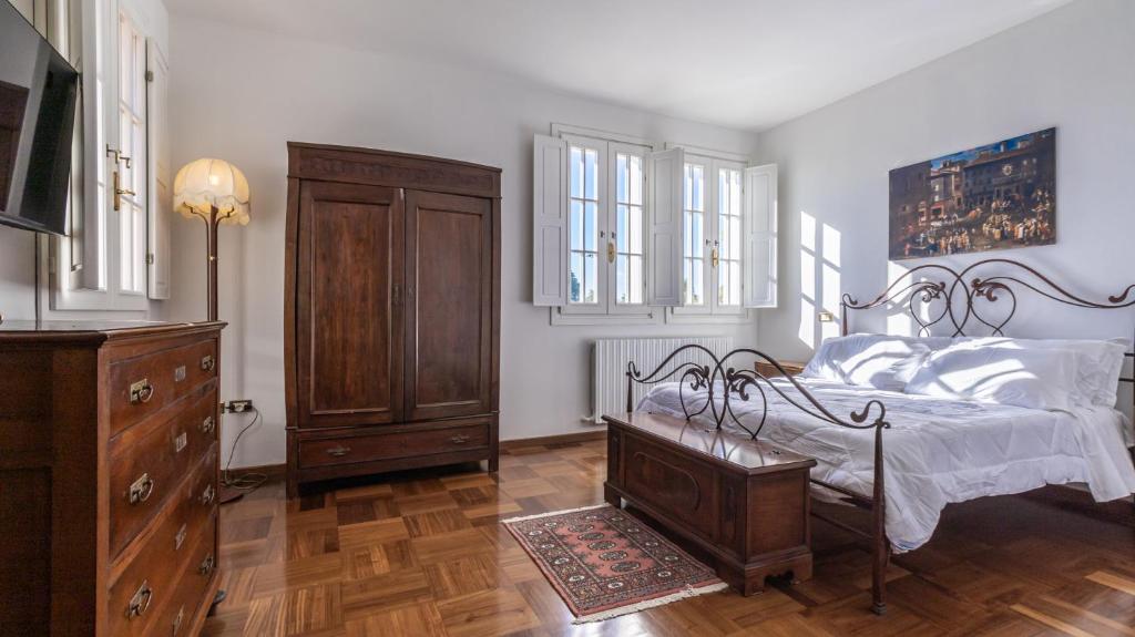 a bedroom with a bed and a dresser and windows at Villa Petrone - Luxury Home tra Bologna e Modena - Wi-Fi, Biliardo, Jacuzzi e piscina in Nonantola