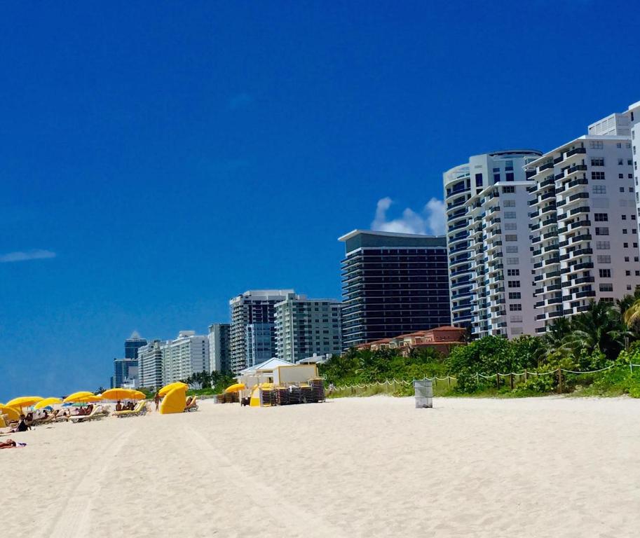 a beach with umbrellas and buildings in the background at Ocean Front Resort Studio in Miami Beach
