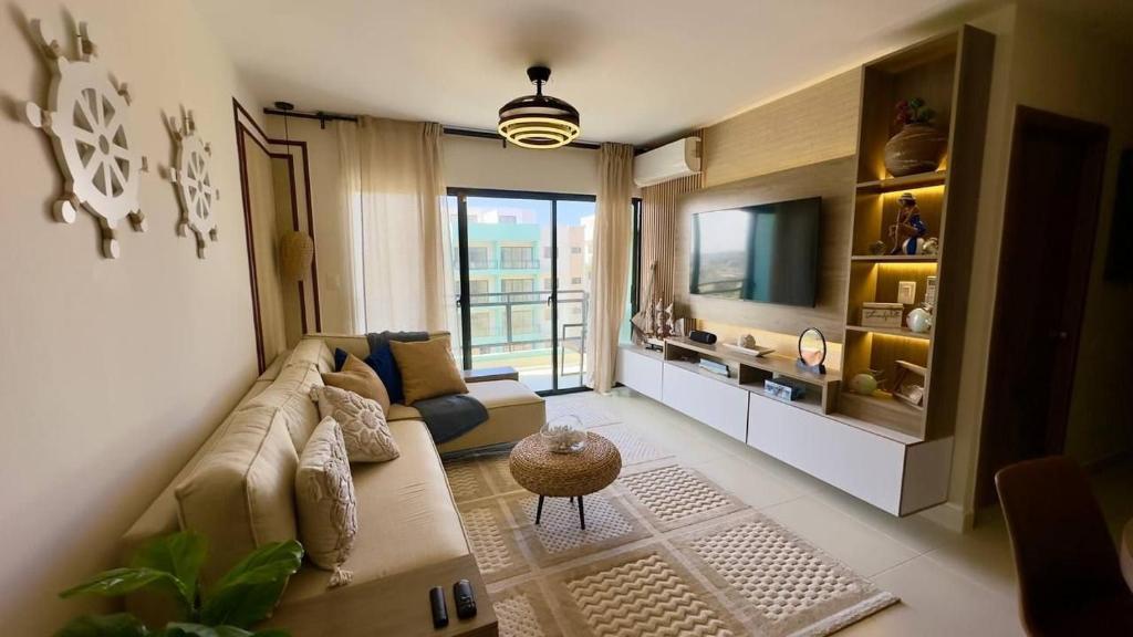 a living room with a couch and a television at Disfruta el Lujo & Descanso en Apartamento 2 Hab. in Punta Cana
