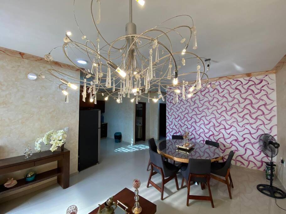 a dining room with a table and a chandelier at Casa Hogar Feliz in San Juan de los Lagos
