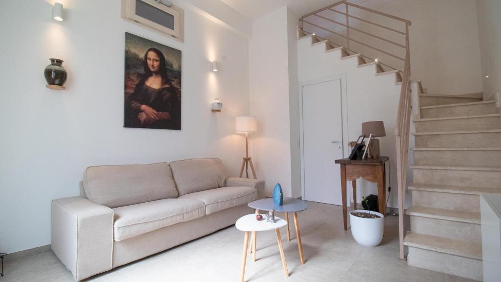 a living room with a couch and a staircase at Corte Coronardi - Elegante casa Campidanese in Quartu SantʼElena