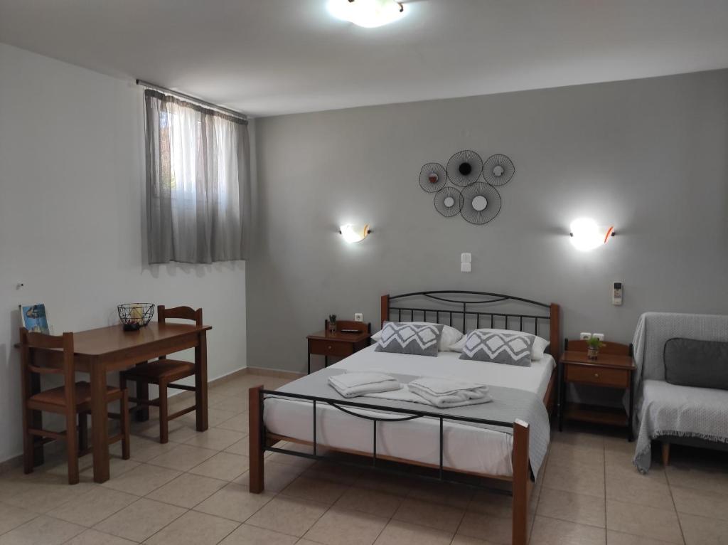 a bedroom with a bed and a table and a couch at Vythos in Adamas