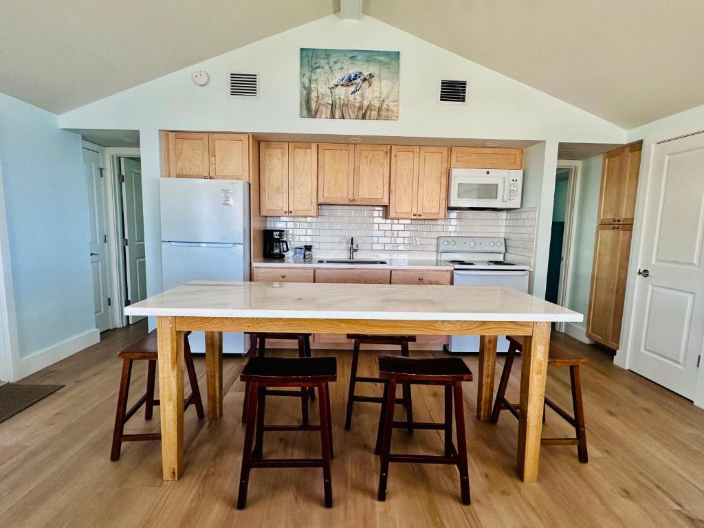 a kitchen with a large wooden table and stools at Ragged Edge Resort & Marina in Islamorada