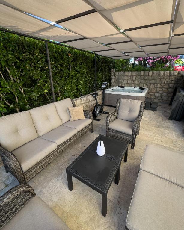 a patio with a couch and chairs and a table at Apartman Dora in Crikvenica