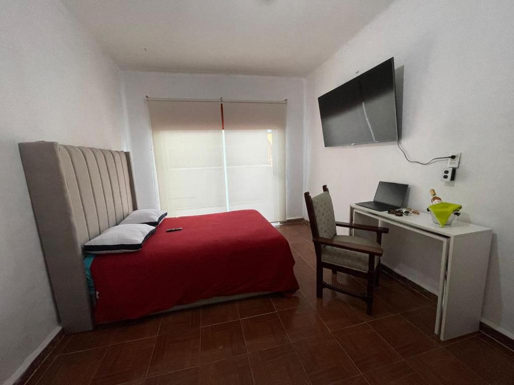 Mantra Suites في مدينة ميكسيكو: غرفة نوم بها سرير ومكتب مع كمبيوتر محمول