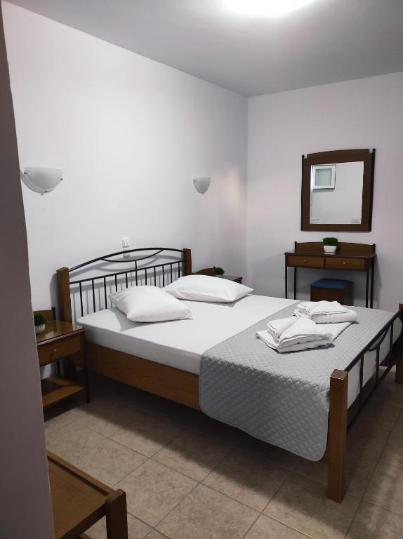 a bedroom with a large bed and a mirror at Vythos in Adamas
