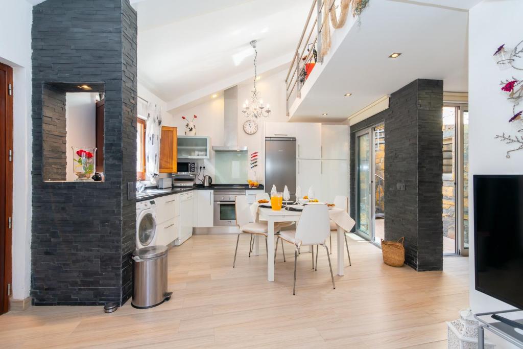 een keuken en eetkamer met een tafel en stoelen bij White & Grey House in Tavira