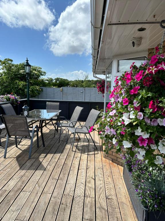 a patio with a table and chairs and flowers at Malahide Guest Rooms in Malahide