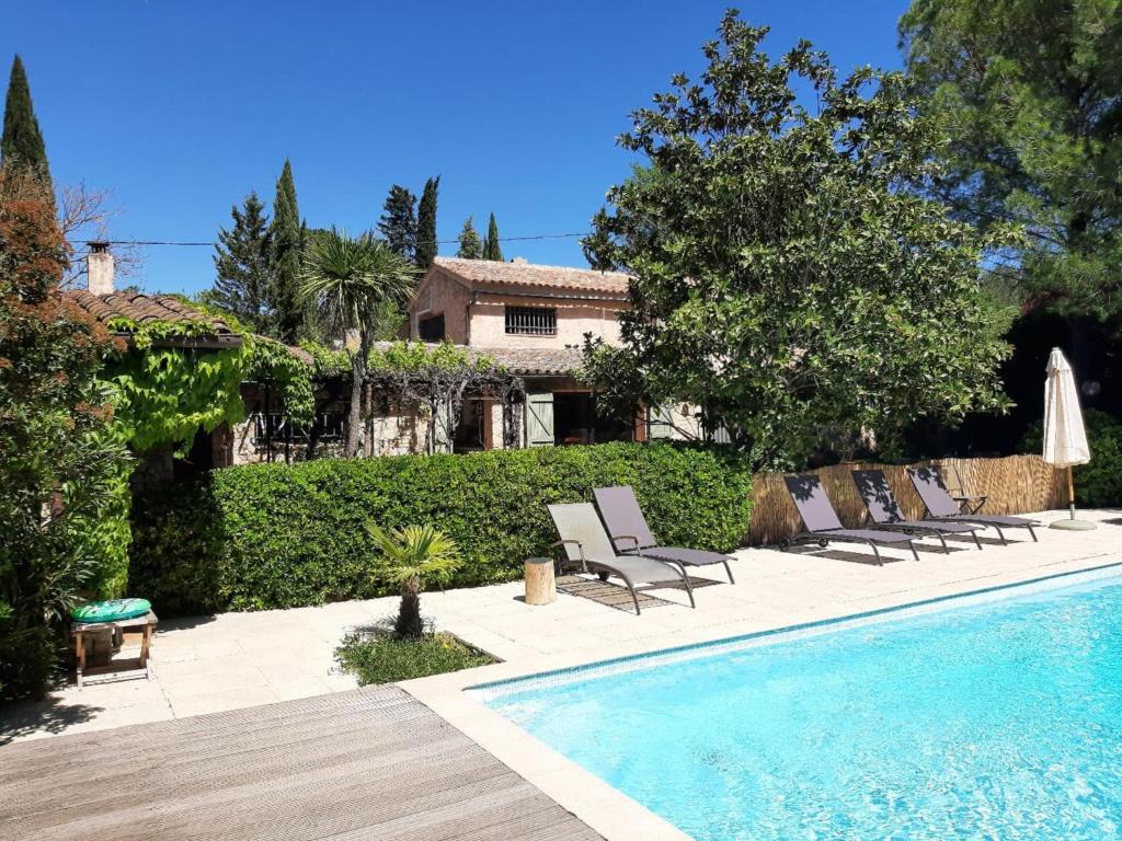 une piscine avec des chaises et une maison dans l'établissement Butterfly, à Lorgues