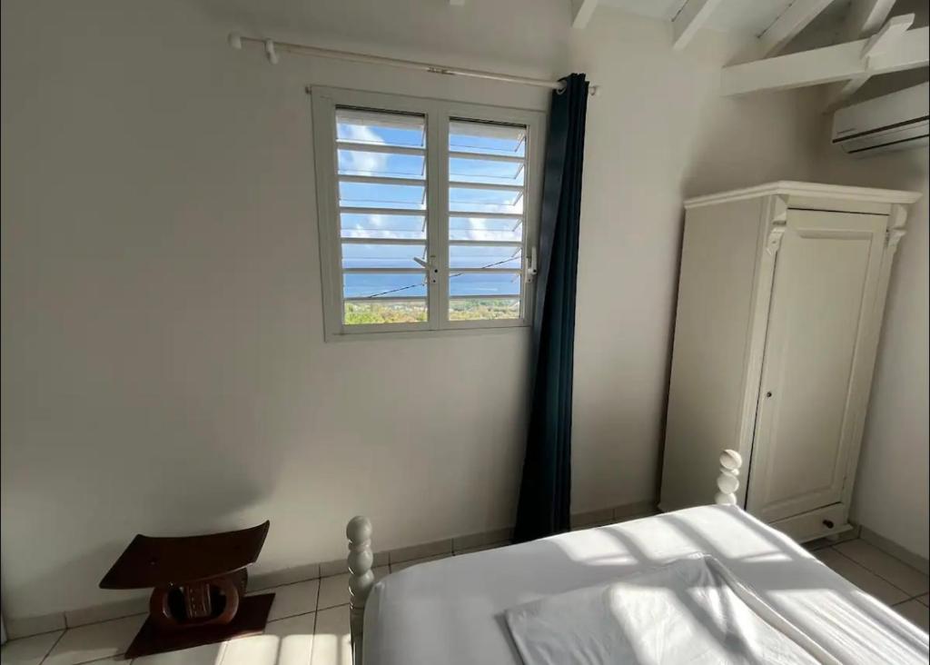 a bedroom with a bed and a window at Le rêve bleu in Sainte-Luce