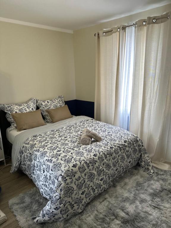 - une chambre avec un lit et une couette grise et blanche dans l'établissement Appartement tout confort, à Rouen